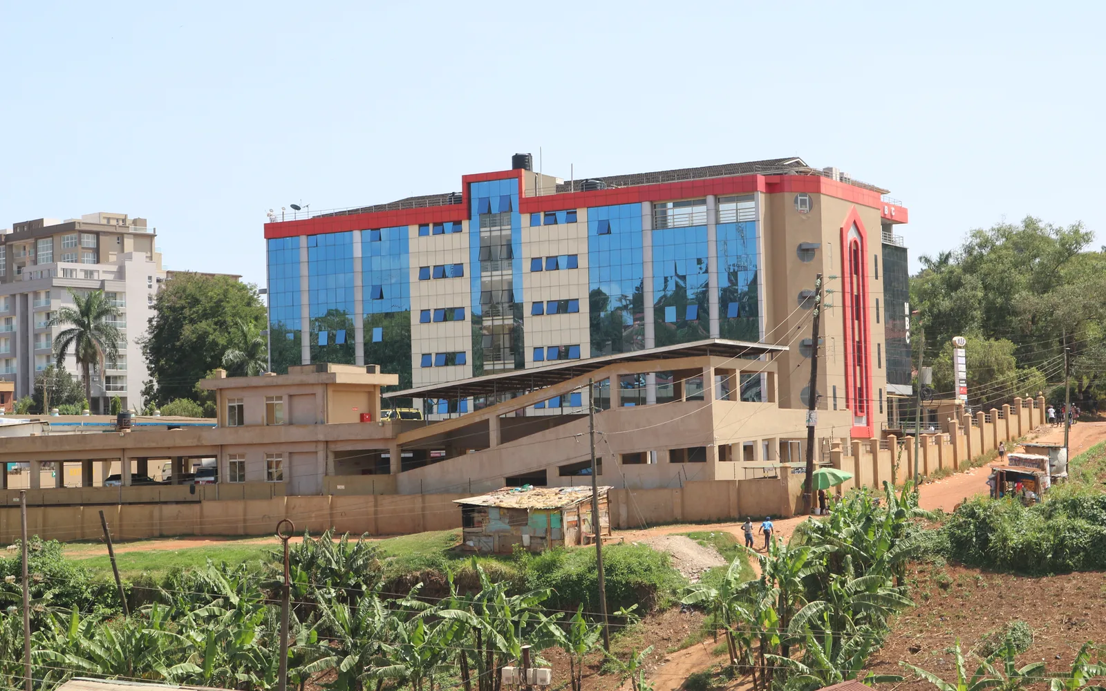 A modern apartment and office building with a car park in front and residential units visible